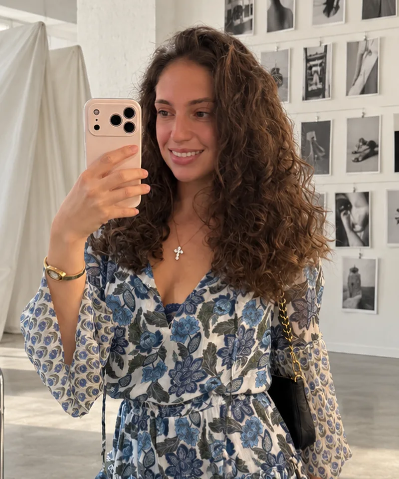 Isabel taking a mirror selfie in a bright photo studio