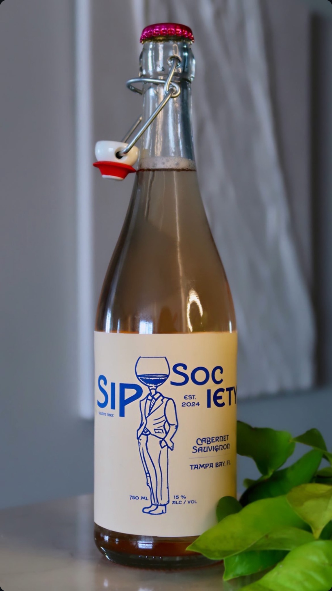 Full Sip Society bottle showing the cream and blue front label.