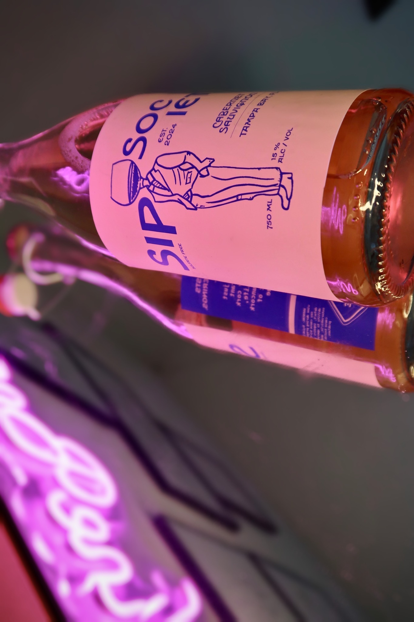Angled close-up of the Sip Society front label and Winehead illustration.